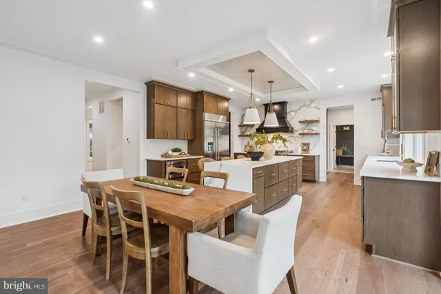 a kitchen with stainless steel appliances kitchen island granite countertop a dining table chairs and sink