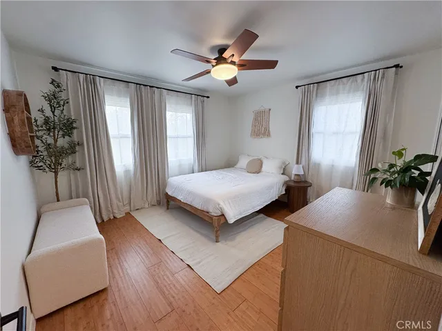 a bedroom with a bed and wooden floor