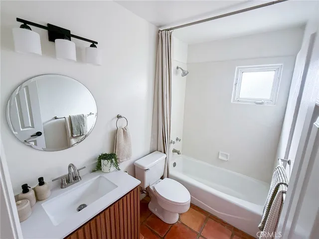 a bath room with a toilet a sink and a mirror