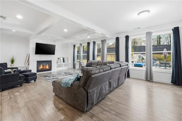 a living room with furniture a fireplace and a flat screen tv