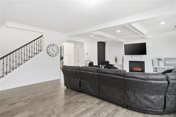 a kitchen with stainless steel appliances granite countertop a stove a sink a microwave a dining table and chairs with wooden floor