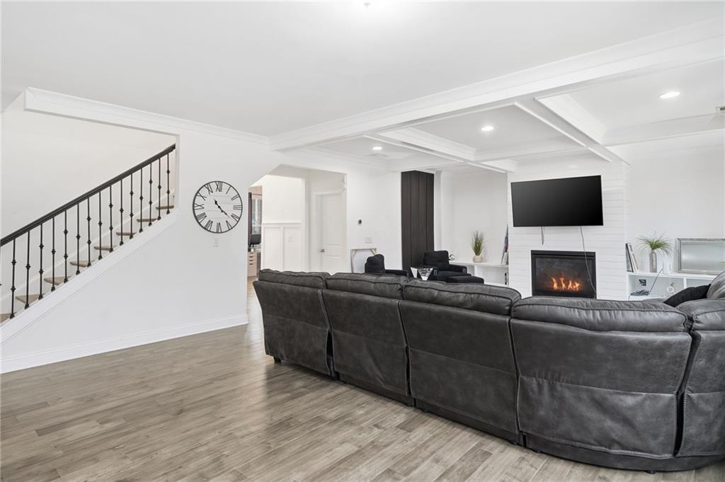 5115 Five Forks Trickum Road Southwest Lilburn, GA 30047 - Photo 13 of 63 a living room with furniture a fireplace and a flat screen tv