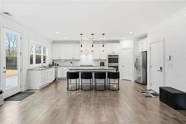 a kitchen with stainless steel appliances granite countertop a stove and chairs