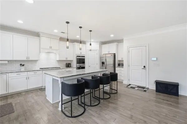 a kitchen with stainless steel appliances granite countertop a stove and white cabinets