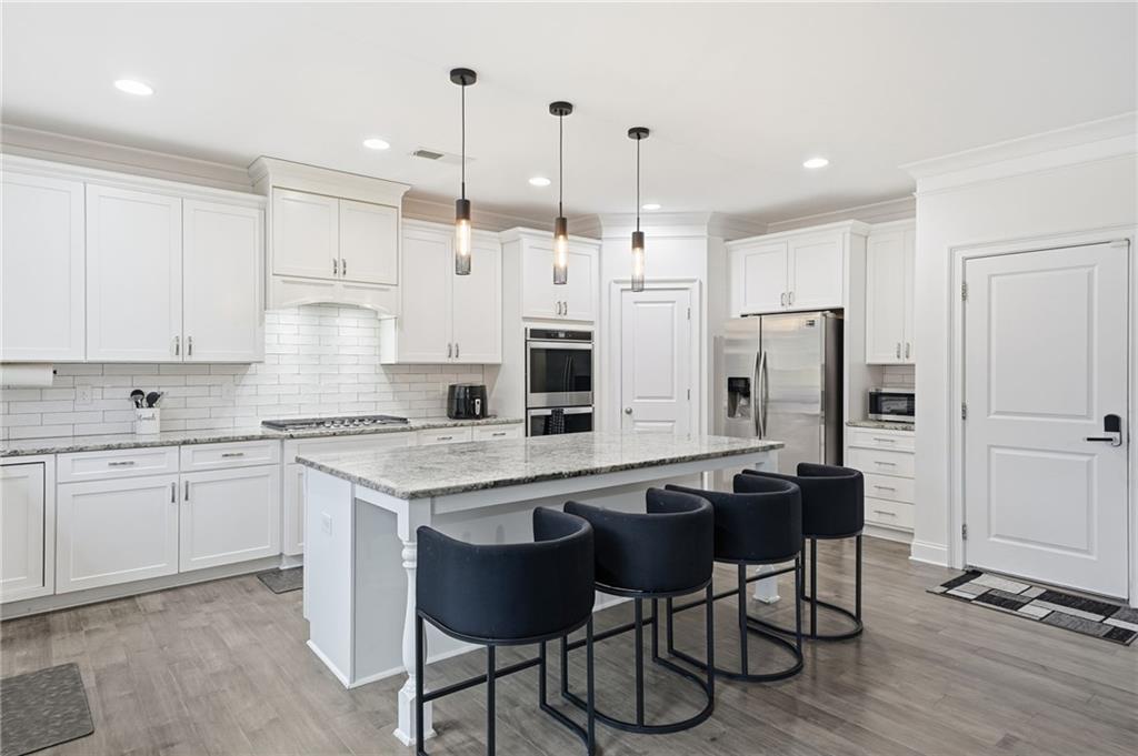 5115 Five Forks Trickum Road Southwest Lilburn, GA 30047 - Photo 19 of 63 a kitchen with stainless steel appliances granite countertop a table chairs sink refrigerator and cabinets