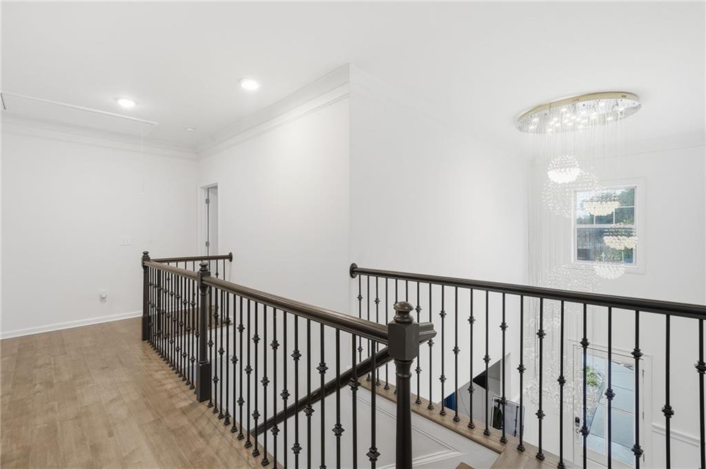 5115 Five Forks Trickum Road Southwest Lilburn, GA 30047 - Photo 27 of 63 a view of staircase with railing and a chandelier
