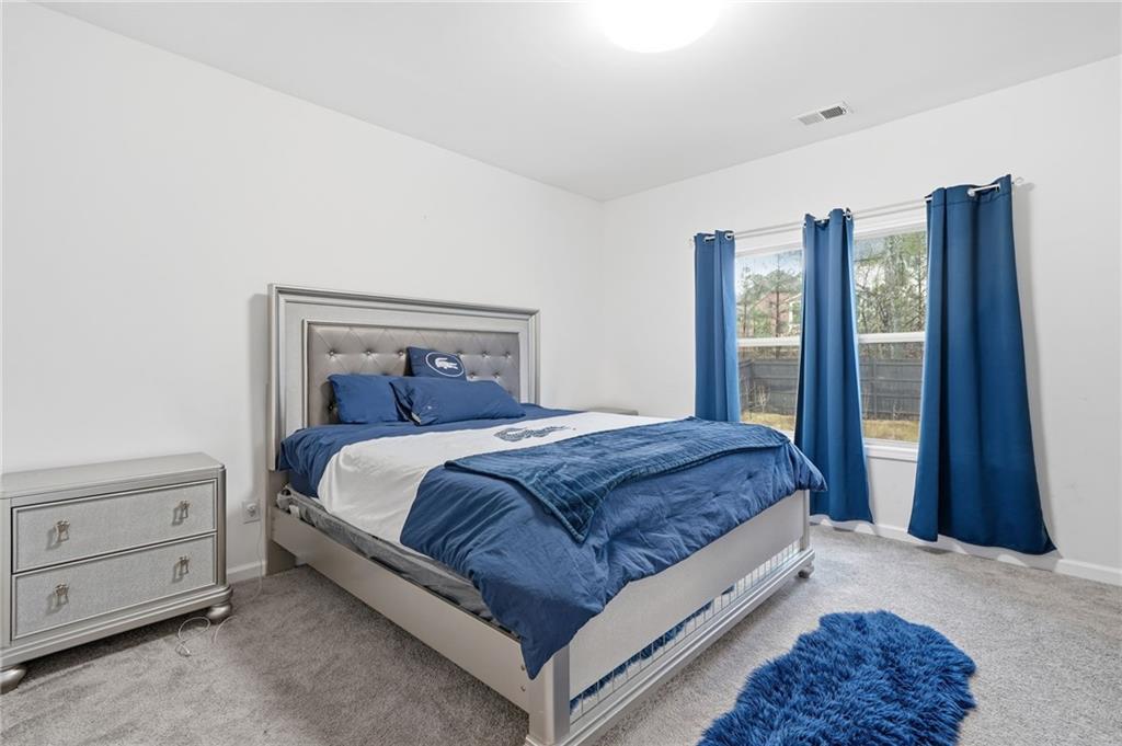 5115 Five Forks Trickum Road Southwest Lilburn, GA 30047 - Photo 36 of 63 a bedroom with a large bed and a dresser