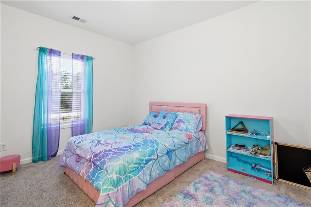 5115 Five Forks Trickum Road Southwest Lilburn, GA 30047 - Photo 40 of 63 a bedroom with a bed and a dresser