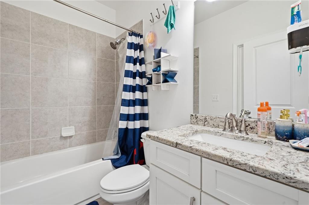 5115 Five Forks Trickum Road Southwest Lilburn, GA 30047 - Photo 43 of 63 a bathroom with a granite countertop sink toilet and shower