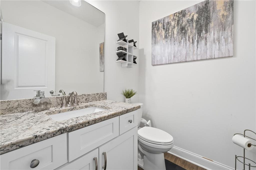 5115 Five Forks Trickum Road Southwest Lilburn, GA 30047 - Photo 44 of 63 a bathroom with a granite countertop toilet sink and mirror