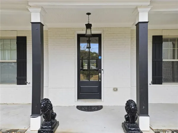 a living room with furniture a flat screen tv and a refrigerator