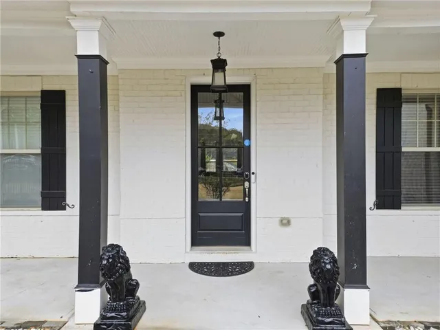 a living room with furniture a flat screen tv and a refrigerator