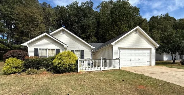 a view of a house with a yard and large trees
