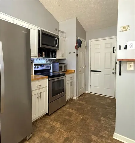 a kitchen with stainless steel appliances a refrigerator stove and microwave