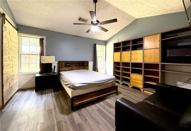 a bedroom with a bed and wooden floor