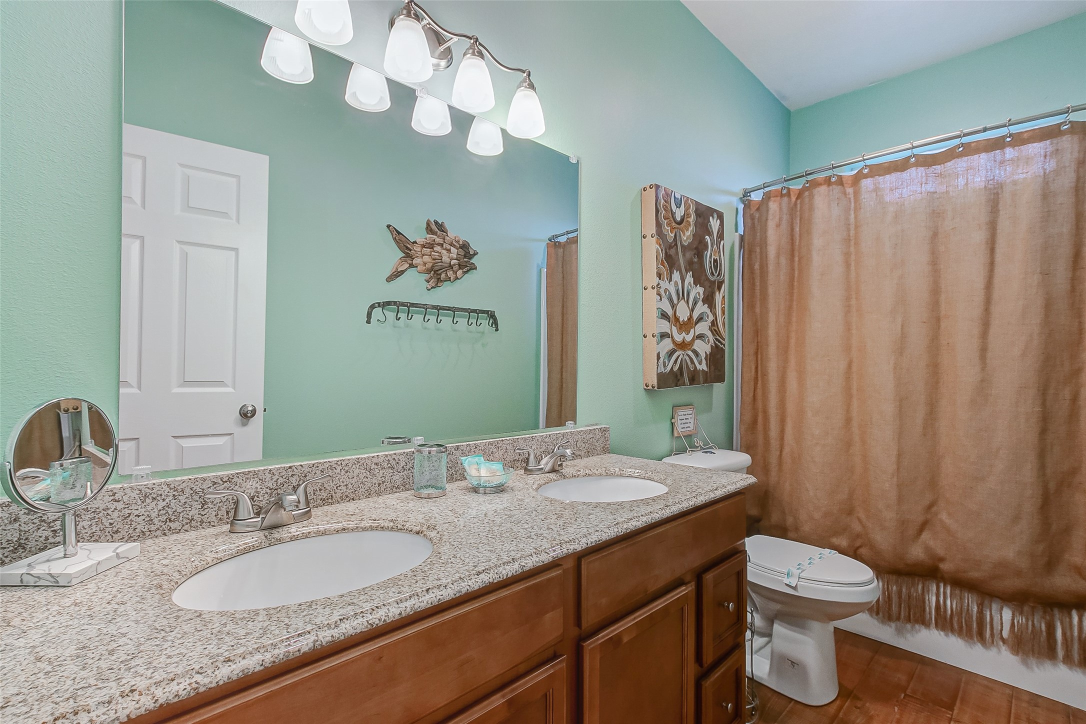 935 Westview Crystal Beach, TX 77650 - Photo 26 of 38 a bathroom with a granite countertop sink a toilet and a mirror