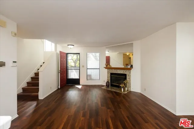 a view of a livingroom with wooden floor and a fireplace