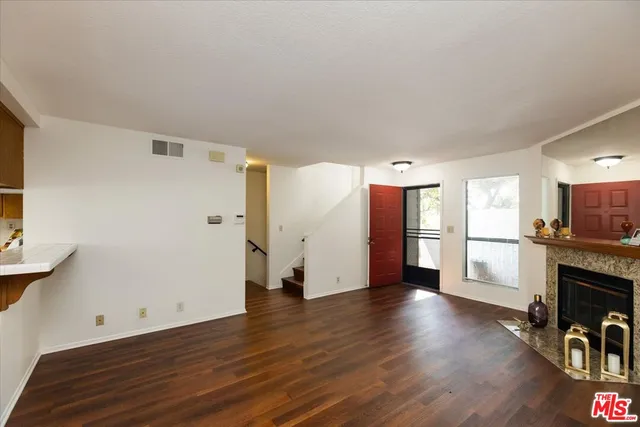 a view of a livingroom with wooden floor and a fireplace