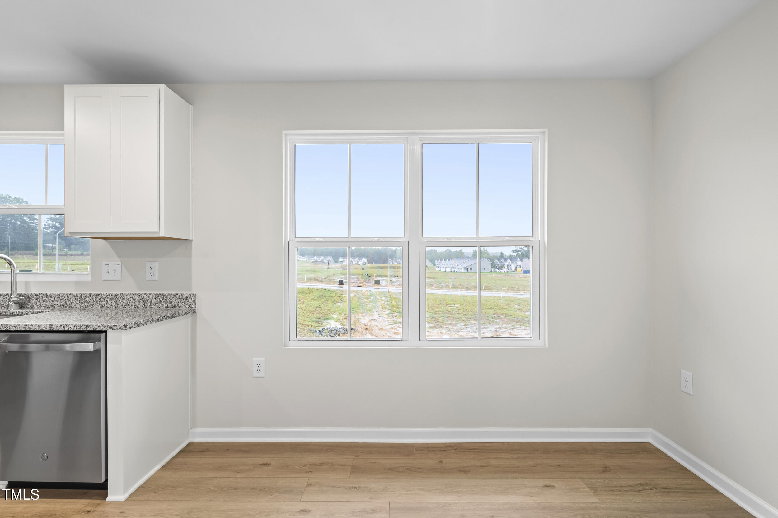 161 Sunny Acrs Road Raleigh, NC 27603 - Photo 7 of 27 a view of a kitchen with wooden floor and a window