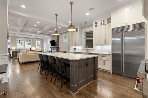 a kitchen with kitchen island granite countertop a sink cabinets and stainless steel appliances