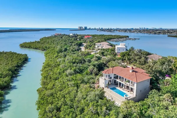 an aerial view of a house with a garden and lake view