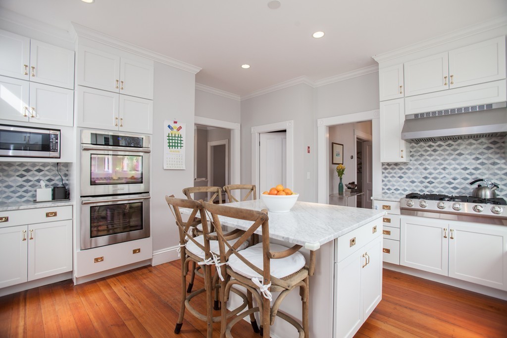 41 Forest Street Wellesley, MA 02481 - Photo 7 of 23 a kitchen with stainless steel appliances kitchen island granite countertop a stove a sink a refrigerator white cabinets and wooden floor