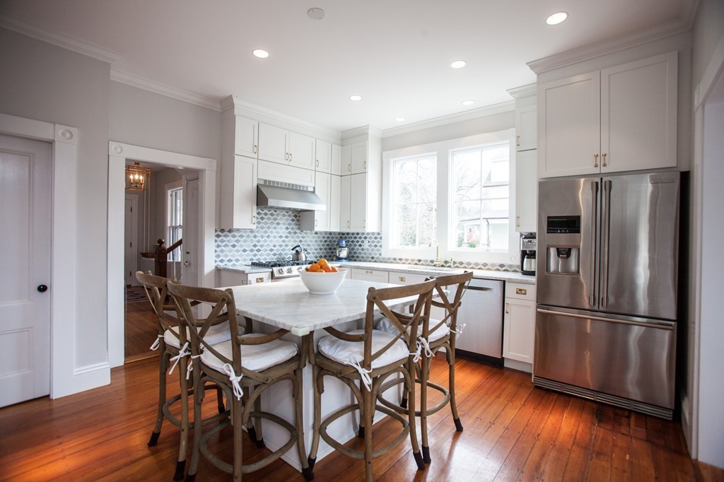 41 Forest Street Wellesley, MA 02481 - Photo 9 of 23 a kitchen with stainless steel appliances a refrigerator a stove a sink and white cabinets with wooden floor