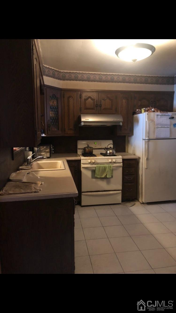 22 Stevens Road Edison, NJ 08817 - Photo 6 of 8 a kitchen with a stove and a microwave