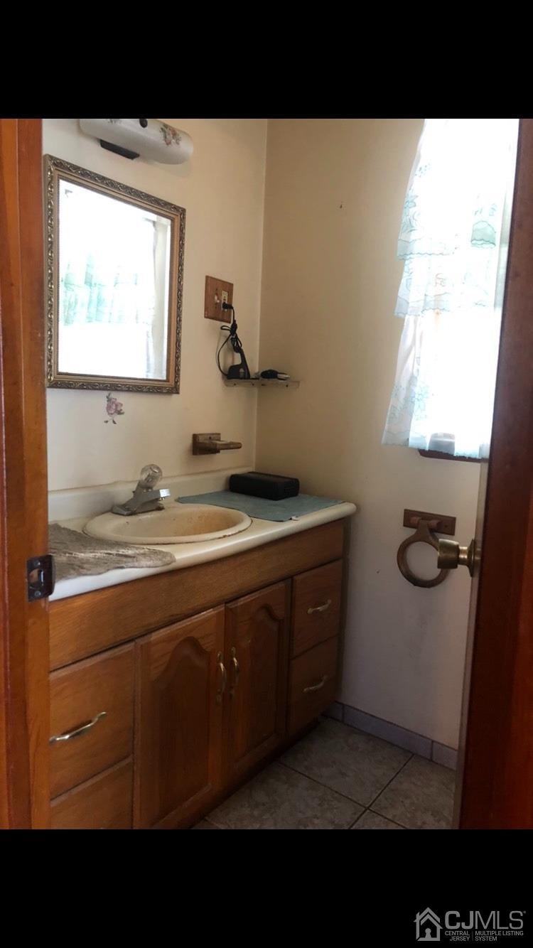 22 Stevens Road Edison, NJ 08817 - Photo 7 of 8 a bathroom with a sink and a mirror