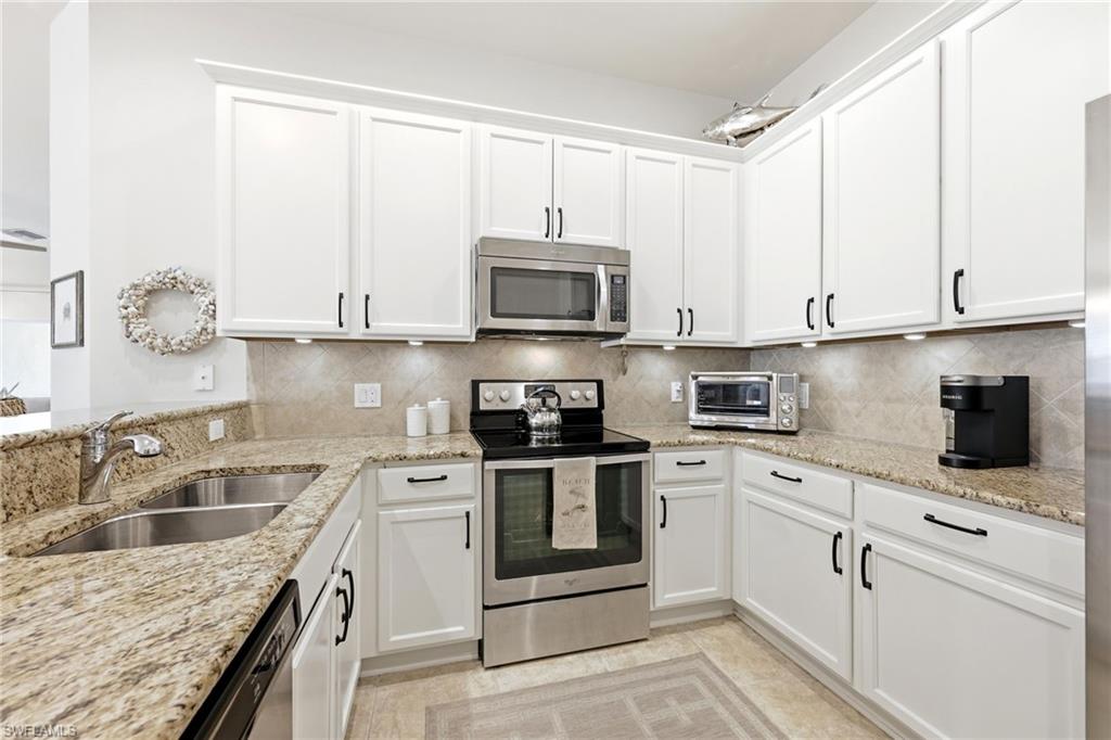 8658 Genova Court Naples, FL 34114 - Photo 10 of 49 Kitchen with Granite Countertops and stainless stell appliances.