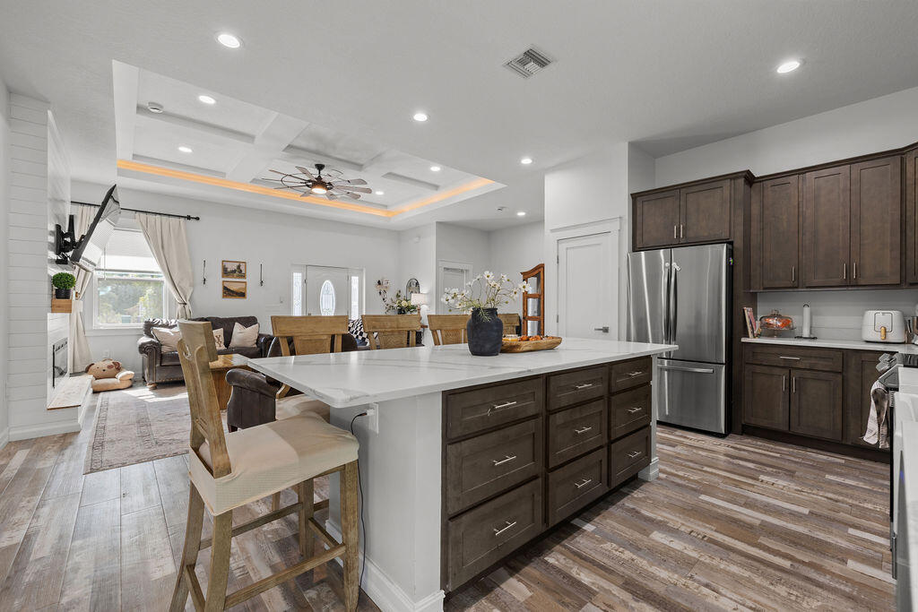 1014 Southwest 11th Street Okeechobee, FL 34974 - Photo 8 of 45 a kitchen with stainless steel appliances granite countertop a refrigerator a sink dishwasher a stove and a dining table with wooden floor