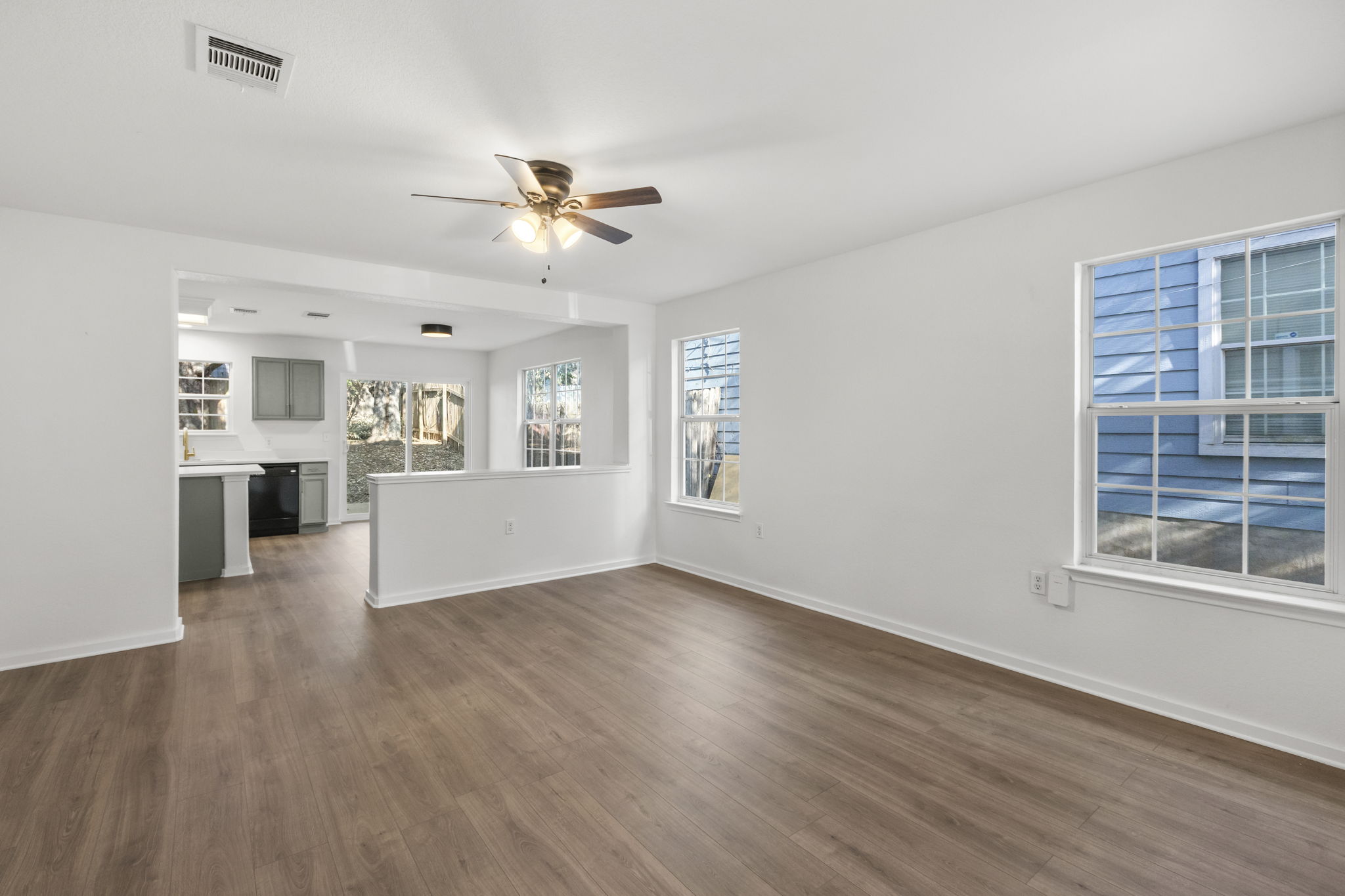 2110 Nogales Trail Austin, TX 78744 - Photo 8 of 37 a view of an empty room with a window and wooden floor