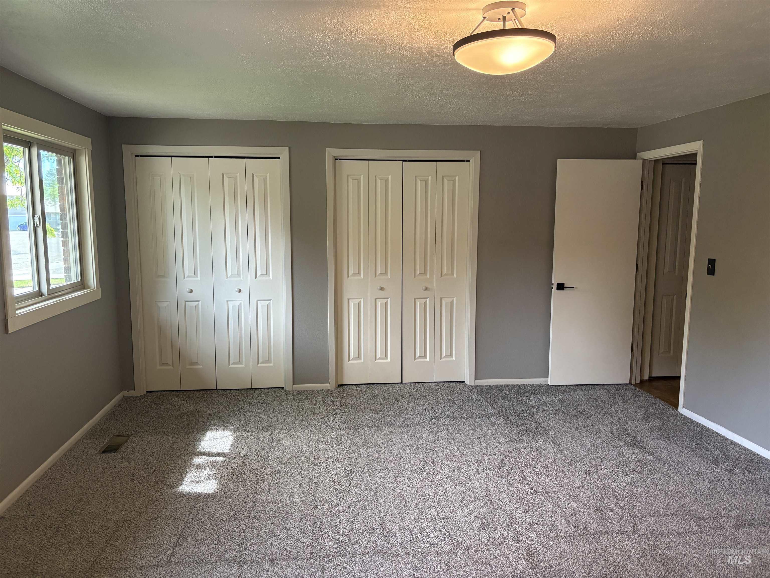 513 Ridge Way Ontario, OR 97914 - Photo 24 of 29 Carpeted interior space featuring a double-pane window, white baseboards, a flush-mount ceiling light fixture, and a solid interior door with dark hardware