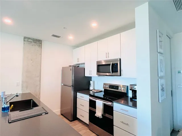 a kitchen with a refrigerator stove and microwave