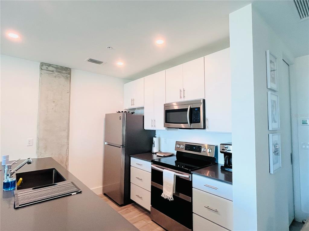 332 Cocoanut Avenue, Unit 507 Sarasota, FL 34236 - Photo 11 of 34 a kitchen with a refrigerator stove and microwave