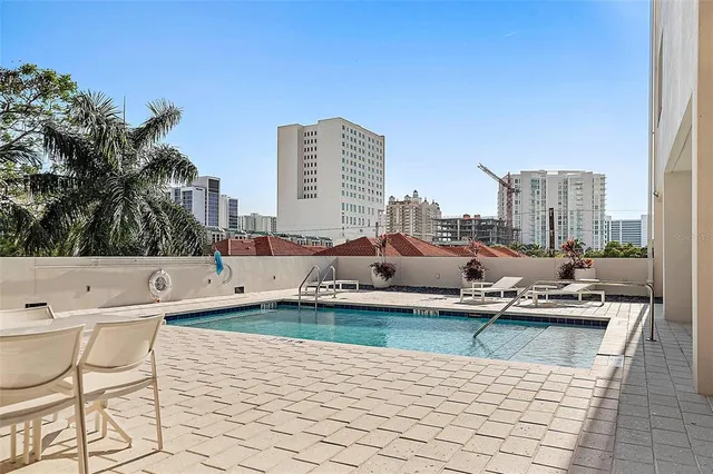 a swimming pool with outdoor seating and city view