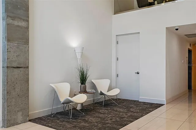 a bathroom with a toilet a chair and a potted plant