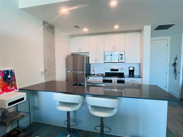 a kitchen with kitchen island a counter top space cabinets and stainless steel appliances