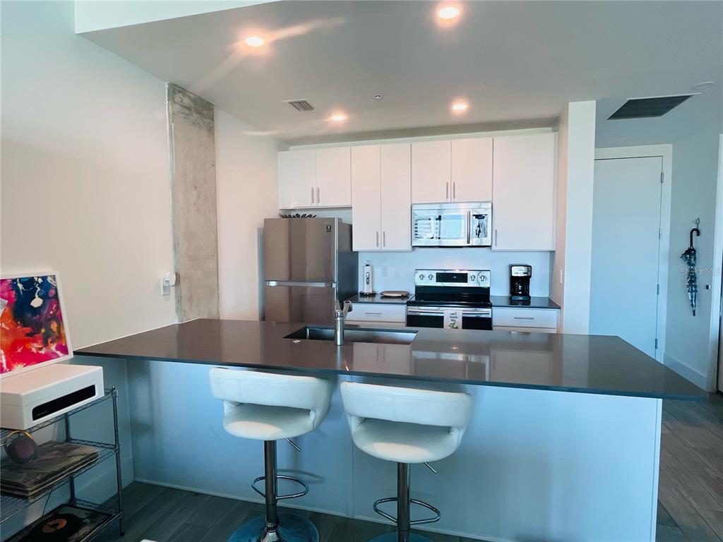 332 Cocoanut Avenue, Unit 507 Sarasota, FL 34236 - Photo 8 of 34 a kitchen with kitchen island a counter top space cabinets and stainless steel appliances