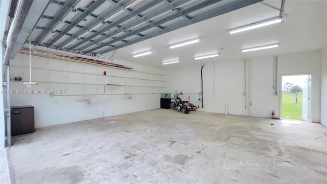 a view of a green field with lots of trees in the background