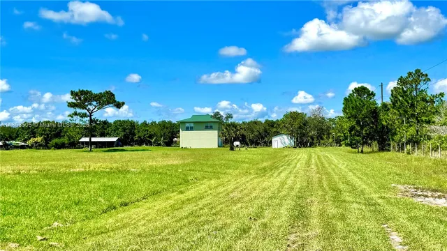 a living room with furniture kitchen view and a chandelier