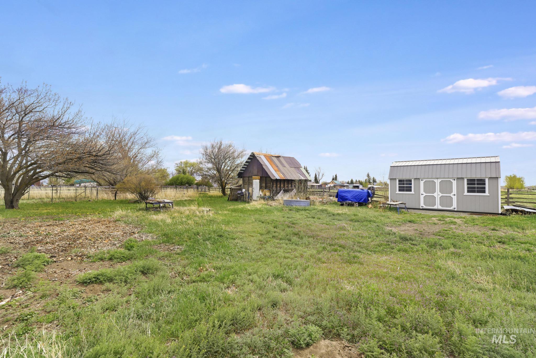 19591 Queen Crown Road Carey, ID 83320 - Photo 28 of 37 Expansive outdoor space featuring a detached storage shed with a gambrel roof and a secondary outbuilding