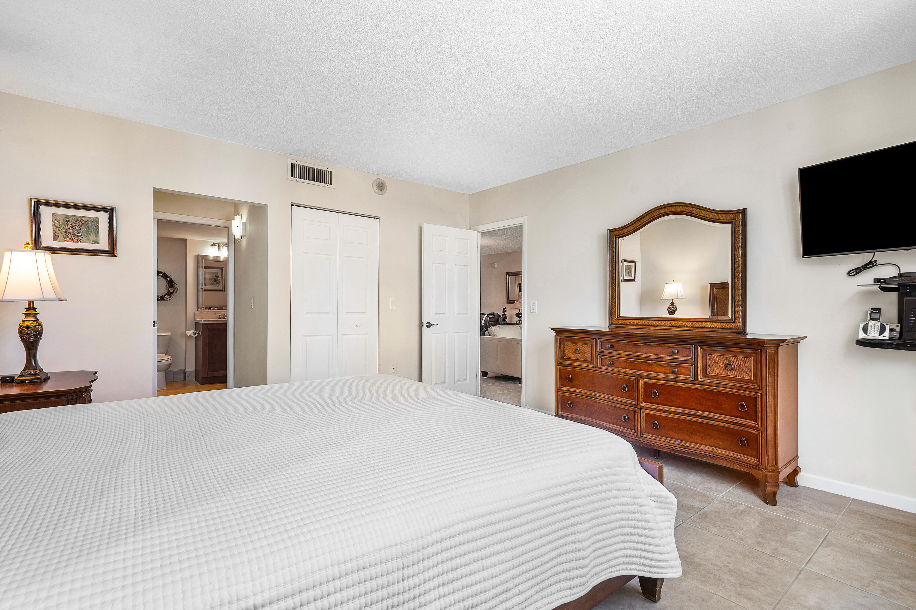 3450 South Ocean Boulevard, Unit 714 Palm Beach, FL 33480 - Photo 17 of 27 a bedroom with a bed and a flat screen tv