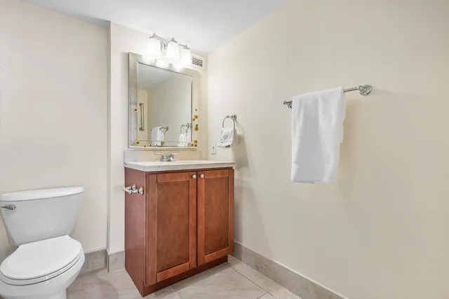 a bathroom with a toilet a sink and mirror