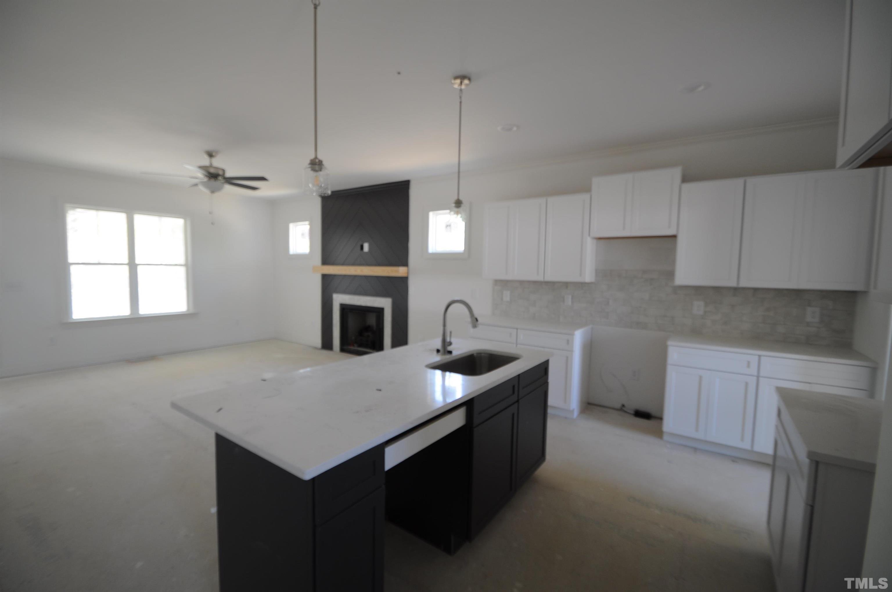 40 Pilot Ridge Road Zebulon, NC 27597 - Photo 3 of 11 a kitchen with a sink a stove a microwave a center island and cabinets