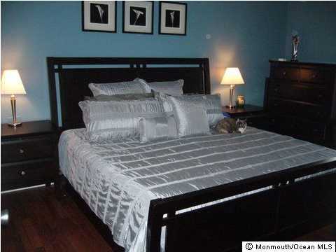 11 Finch Road Howell, NJ 07731 - Photo 3 of 3 a bed sitting in a bedroom next to a lamp
