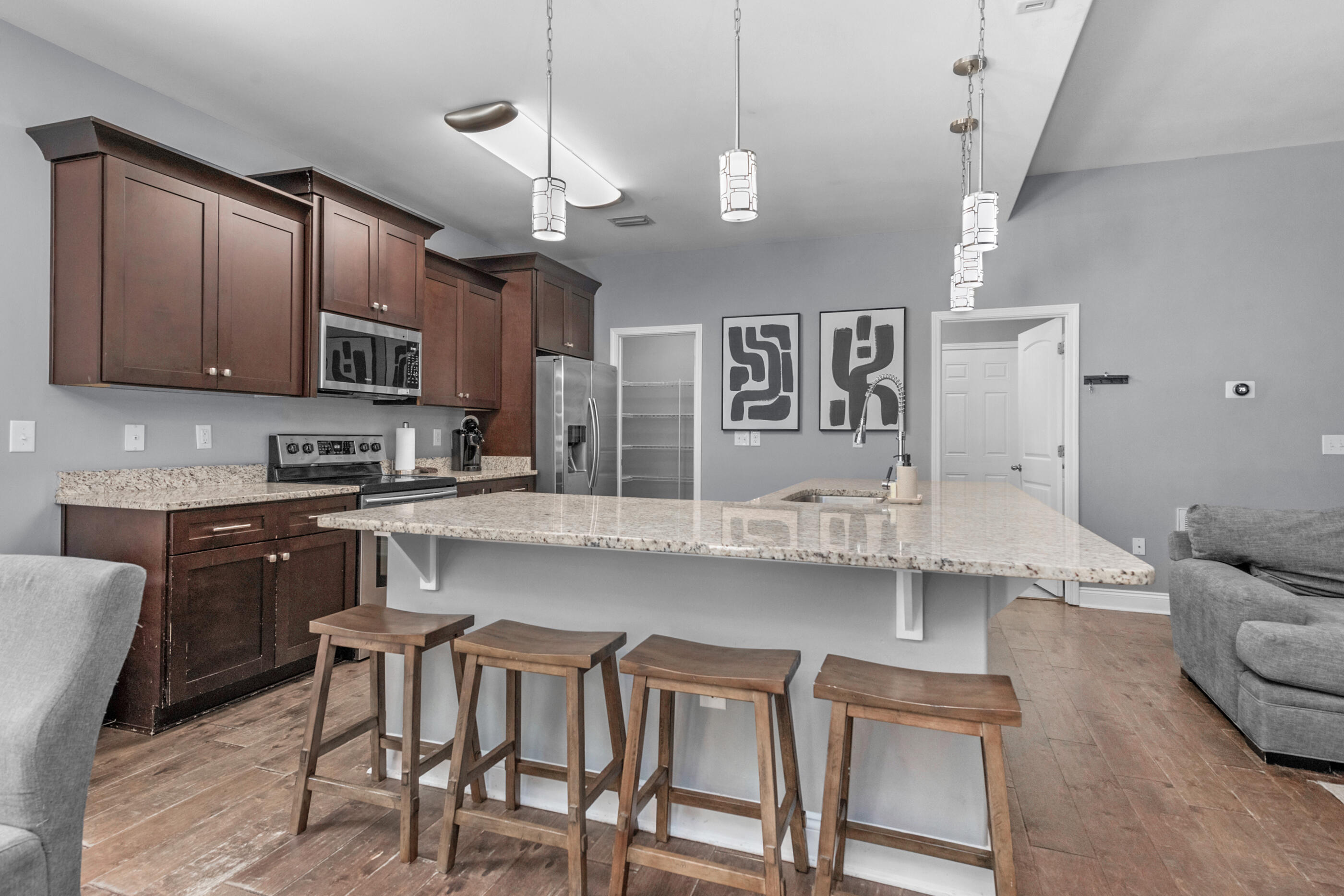 2269 Tom Street Navarre, FL 32566 - Photo 23 of 40 a kitchen with stainless steel appliances granite countertop a stove top oven a sink a dining table and chairs with wooden floor