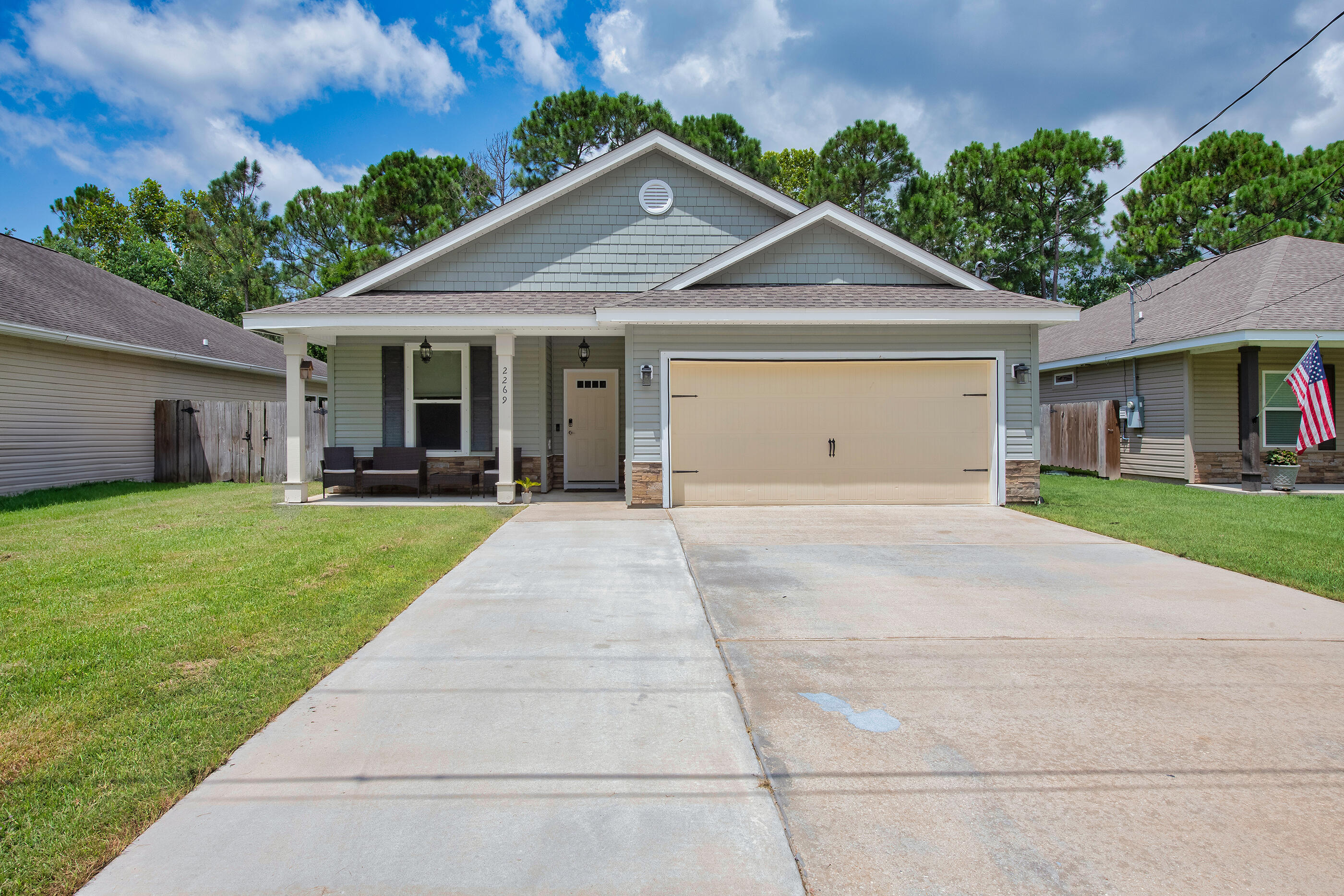 2269 Tom Street Navarre, FL 32566 - Photo 39 of 40 a front view of a house with a yard and potted plants