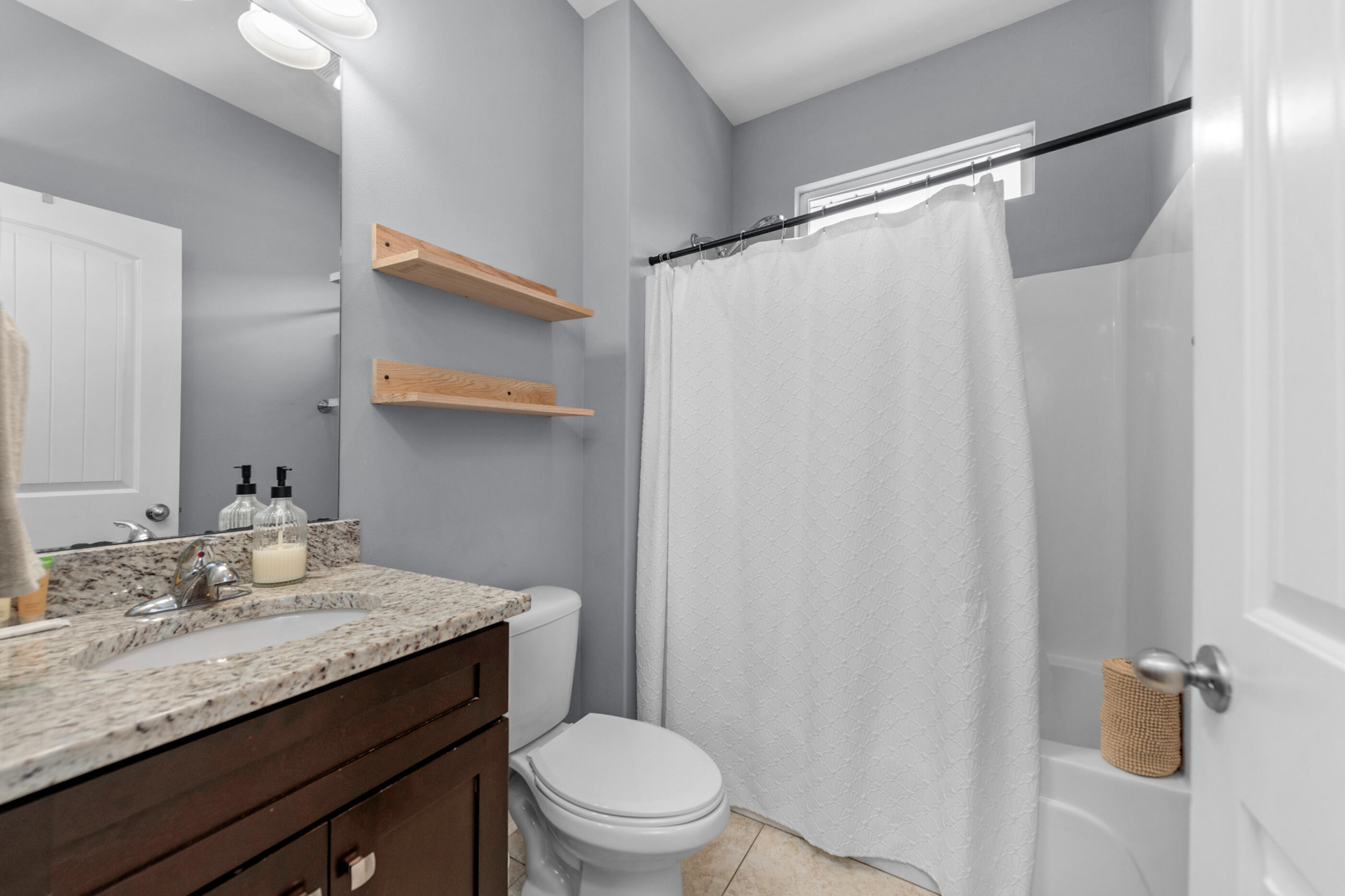 2269 Tom Street Navarre, FL 32566 - Photo 7 of 40 a bathroom with a granite countertop sink toilet and shower