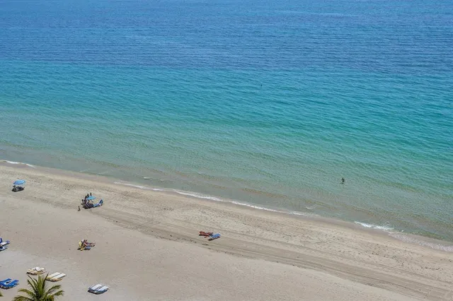 a living room with furniture a floor to ceiling window and a flat screen tv